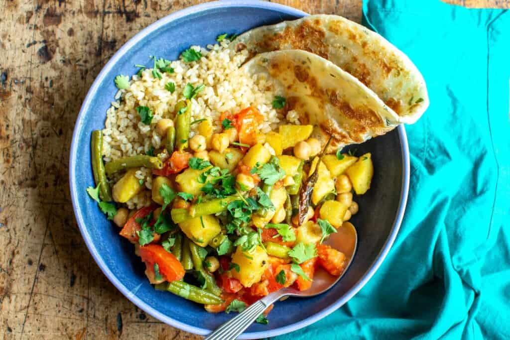 green bean curry with a pieces of flat bread