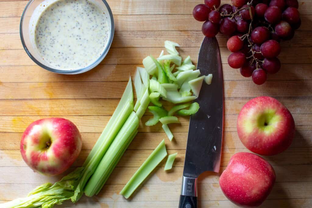 The celery being sliced on a cutting board