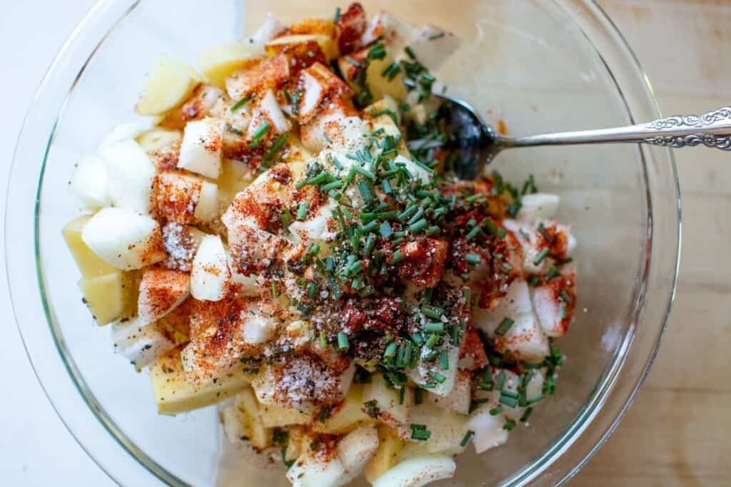 Potatoes with spices and chives on top of them