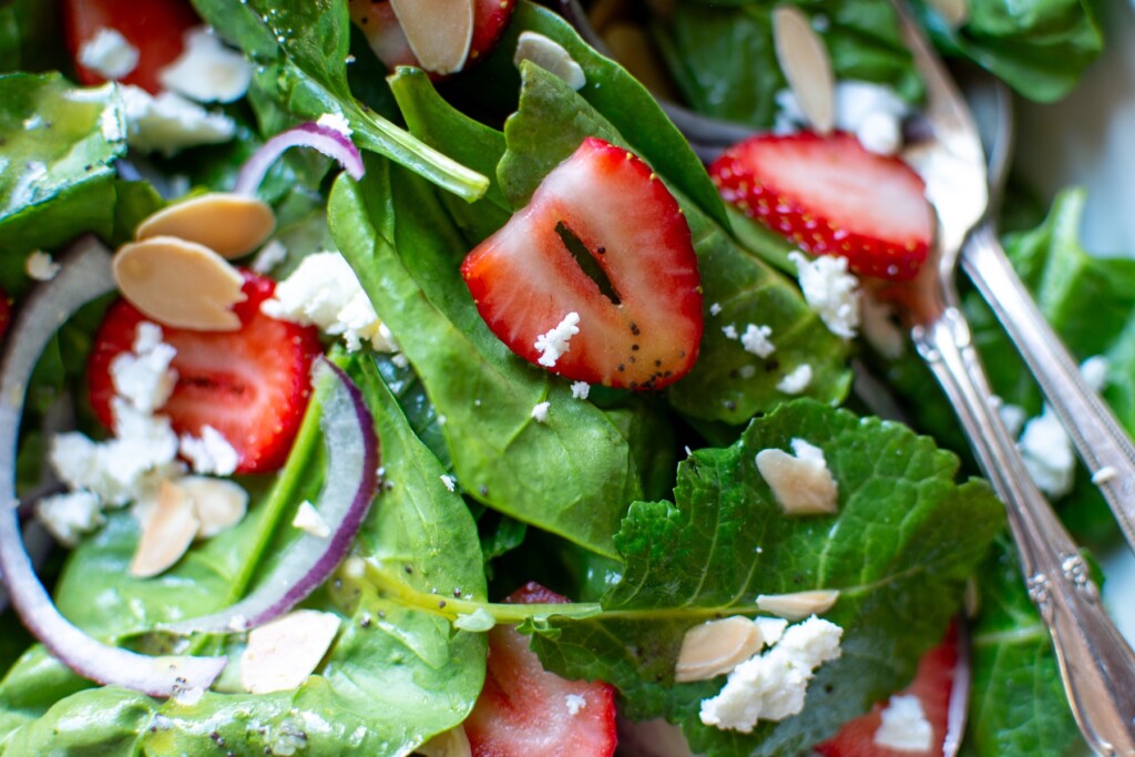 A spinach salad with sliced strawberries