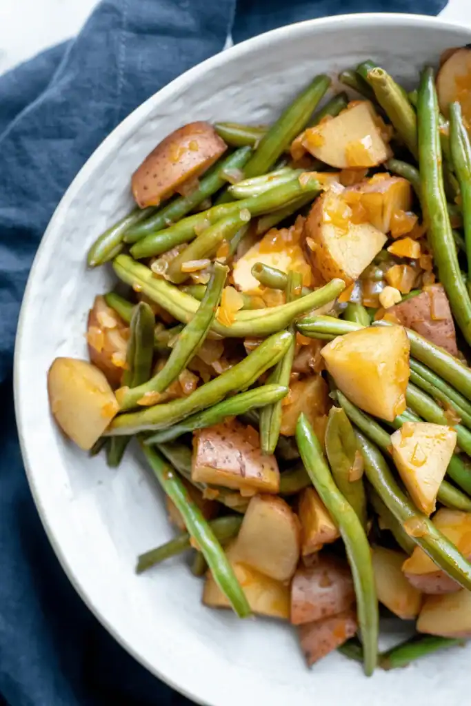 green beans and potatoes in a white dish