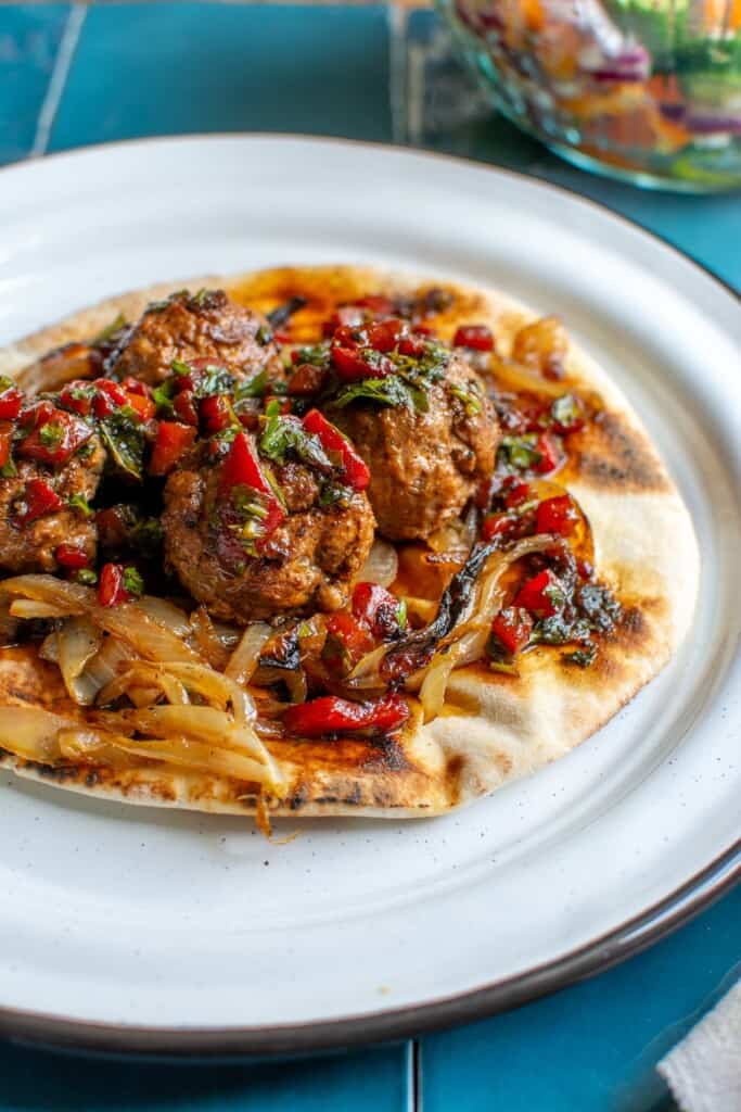 turkish meatballs on a pita with caramelized onions