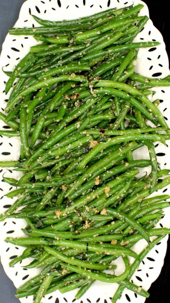 green beans topped with sesame seeds in a white plate