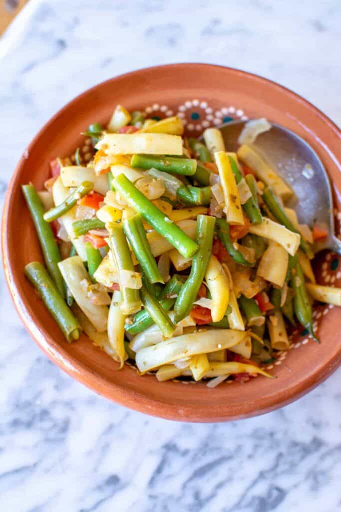 green beans with tomatoes in a shallow orange dish