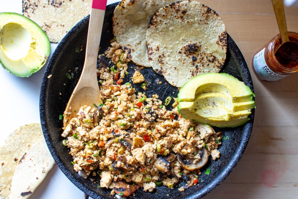 tofu scramble in a frying pan with tortillas