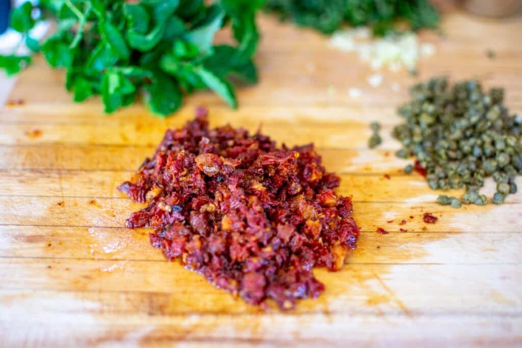sundried tomatoes and capers on a cuting board