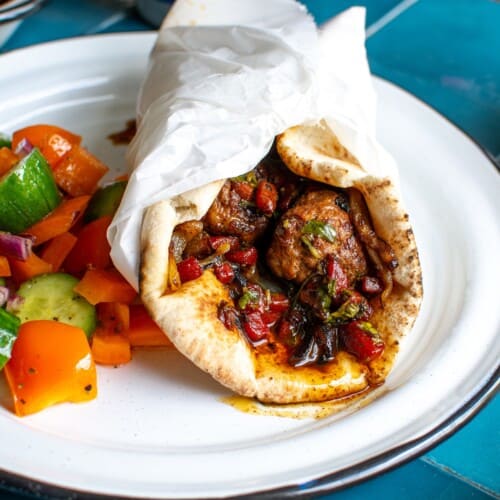 a turkish meatball wrap on a white plate