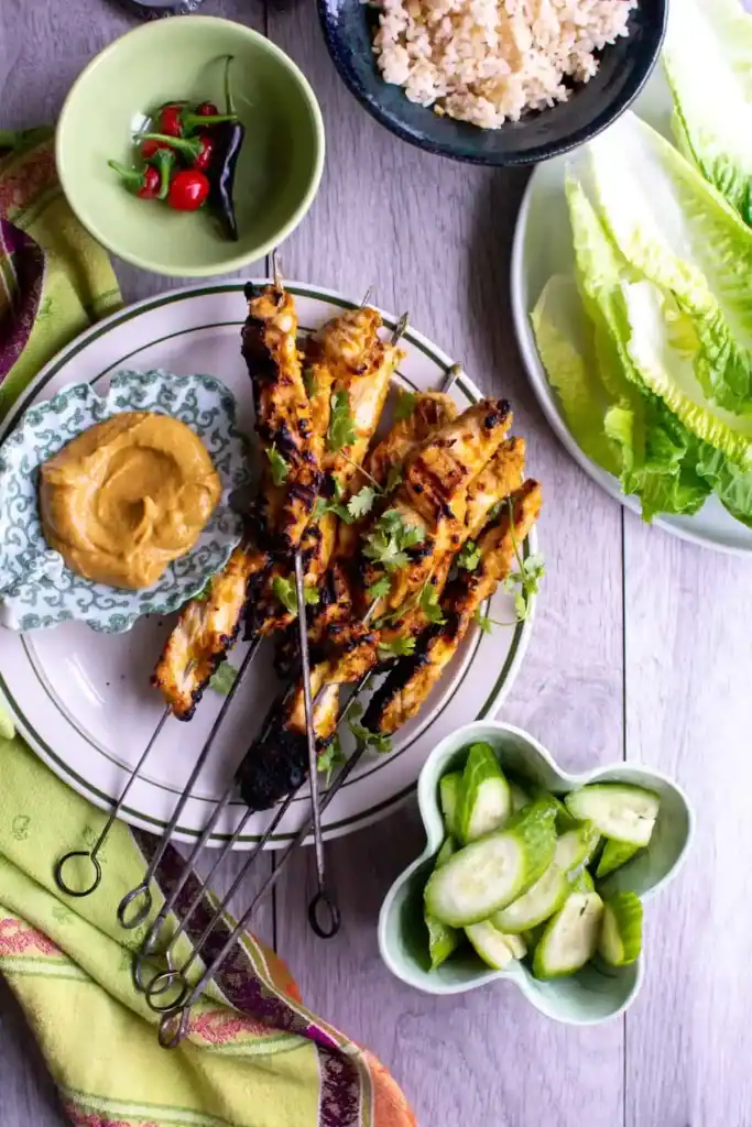 chicken skewers with peanut sauce in a plate