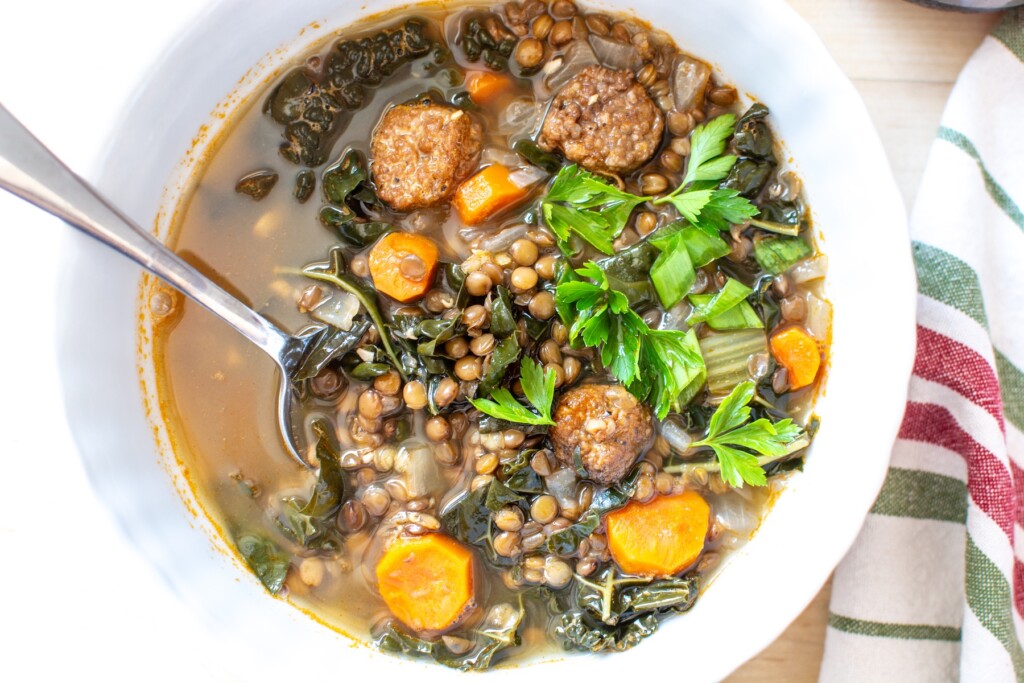 Italian lentil soup with sausage in a white bowl