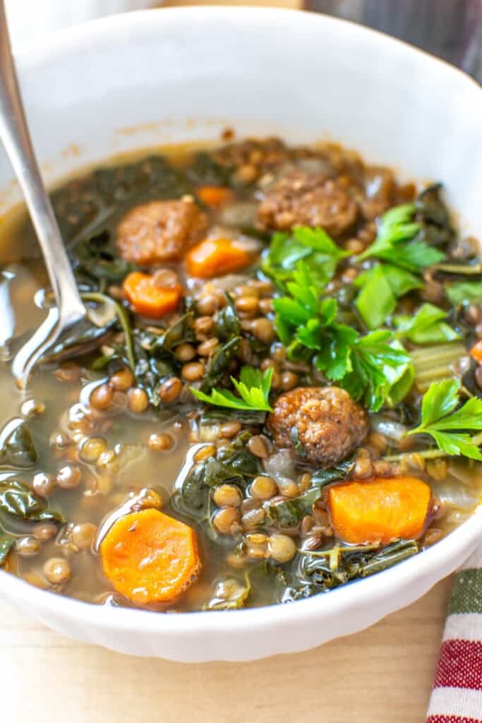 lentil soup in a white bowl with a spoon