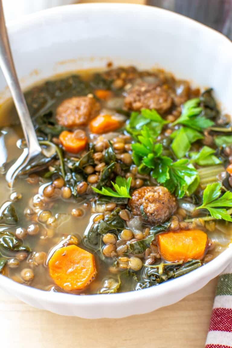 lentil soup in a white bowl with a spoon