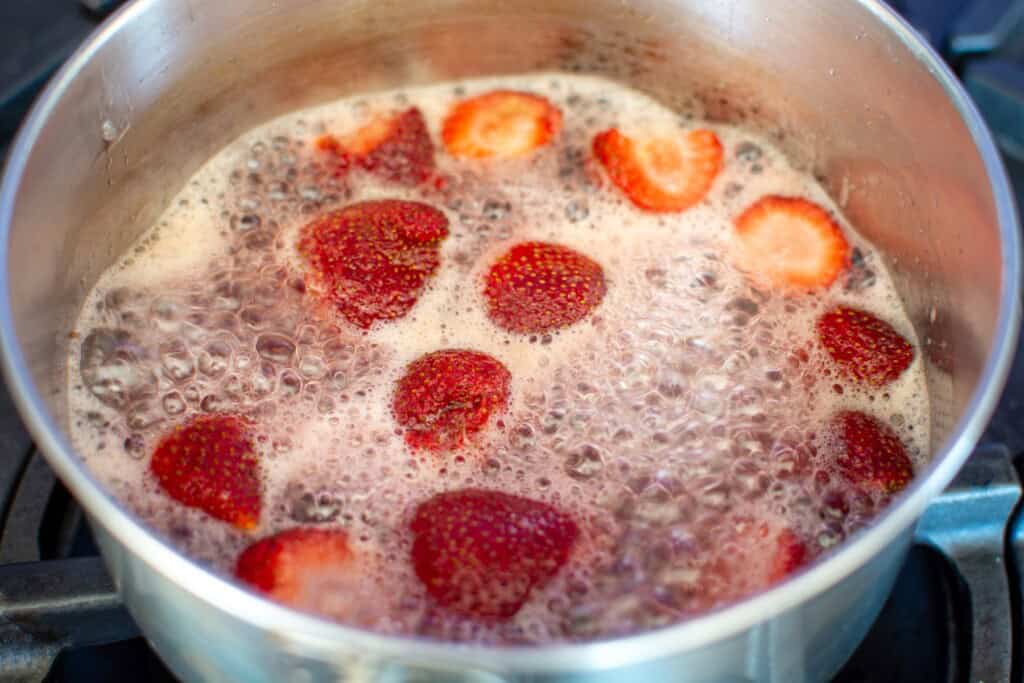 strawberries in sugar water in a metal saucepan