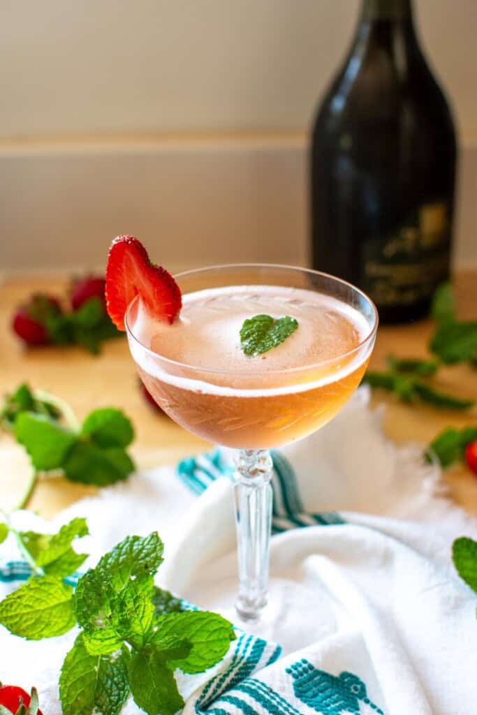 A strawberry prosecco cocktail in a coupe glass