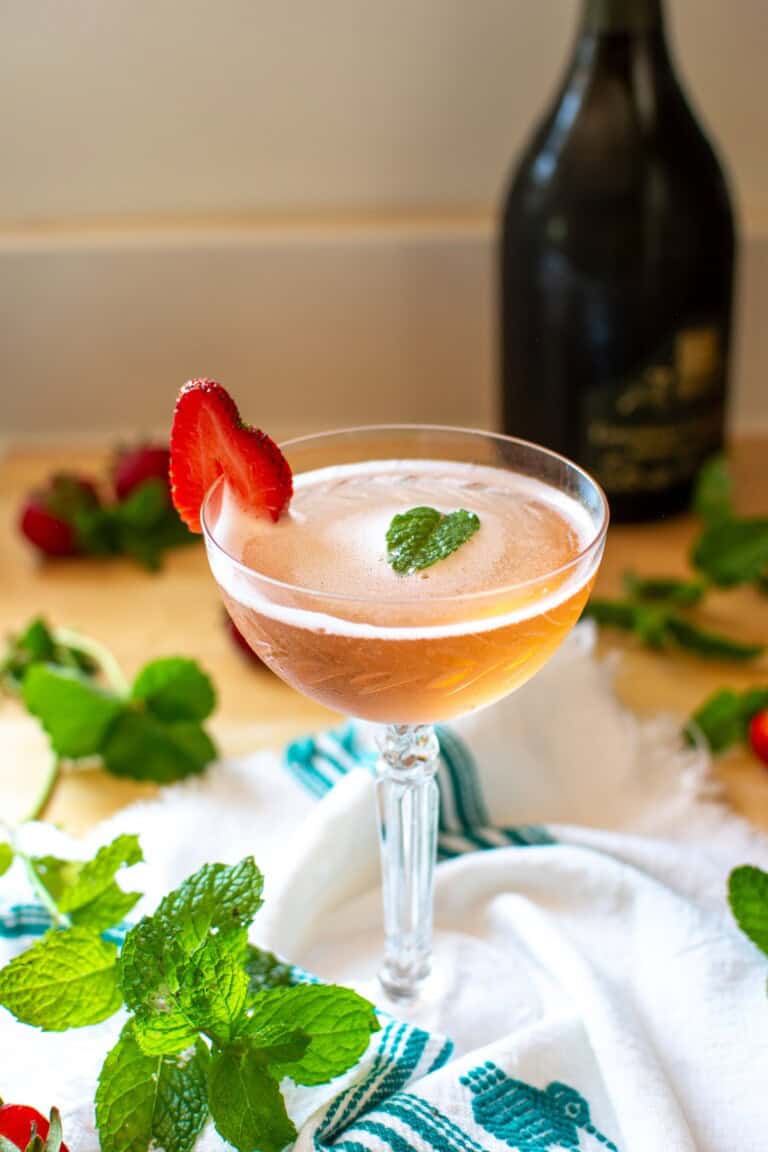 A strawberry prosecco cocktail in a coupe glass