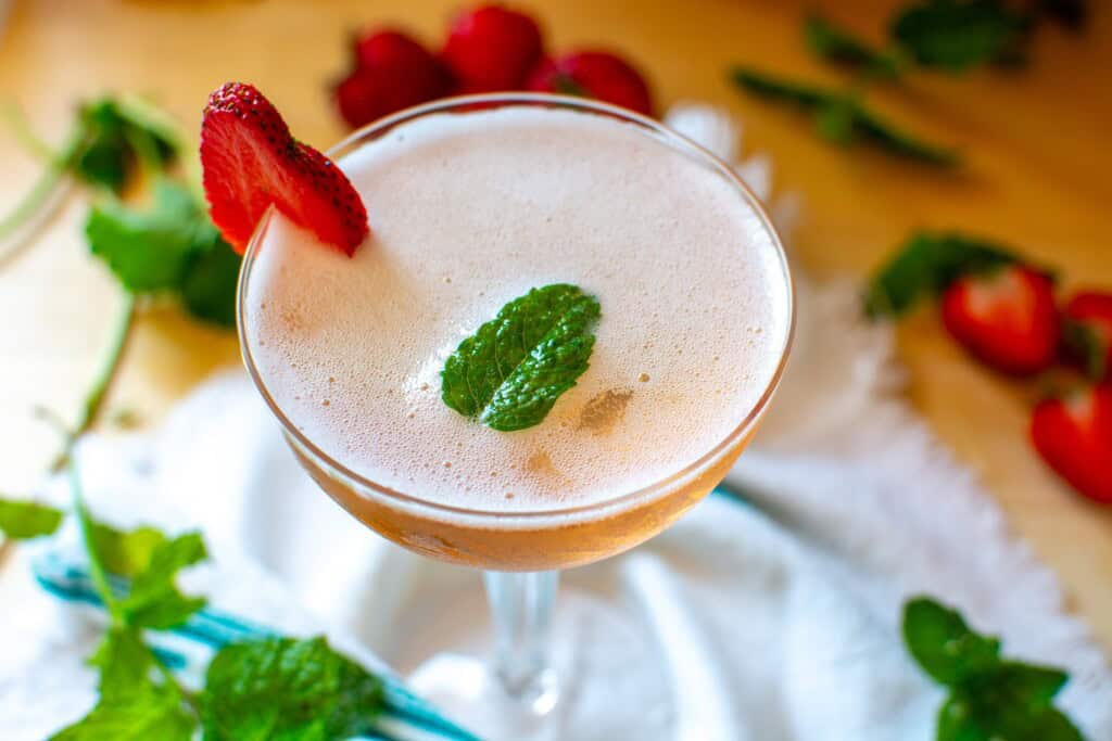 a strawberry prosecco cocktail with a strawberry garnish