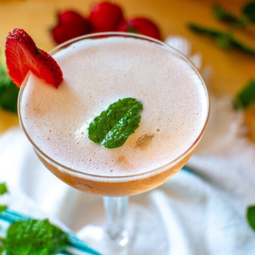 a strawberry prosecco cocktail with a strawberry garnish