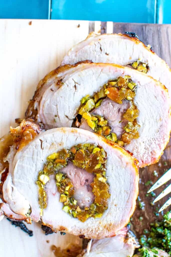 pistachio apricot stuffed pork loin in a wooden board