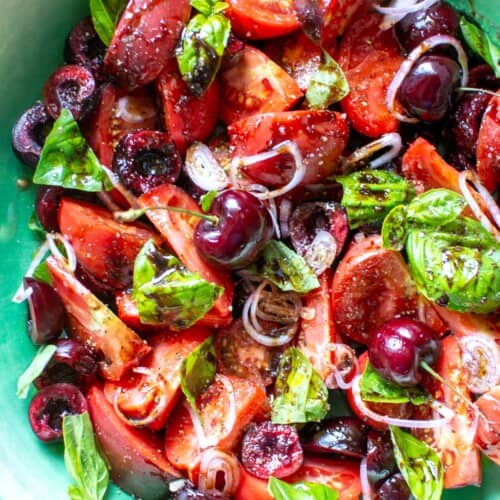 tomatoes and cherry salad in a green bowl