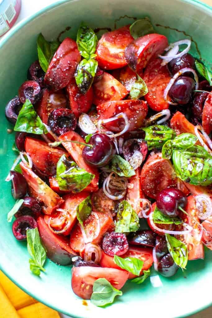 tomatoes and cherry salad in a green bowl