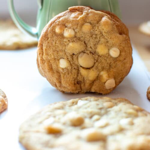 white chocolate macadamia nut cookies next to a green mug