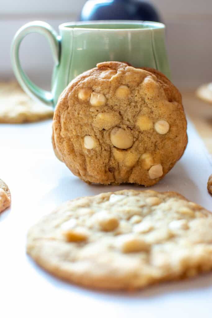 white chocolate macadamia nut cookies next to a green mug