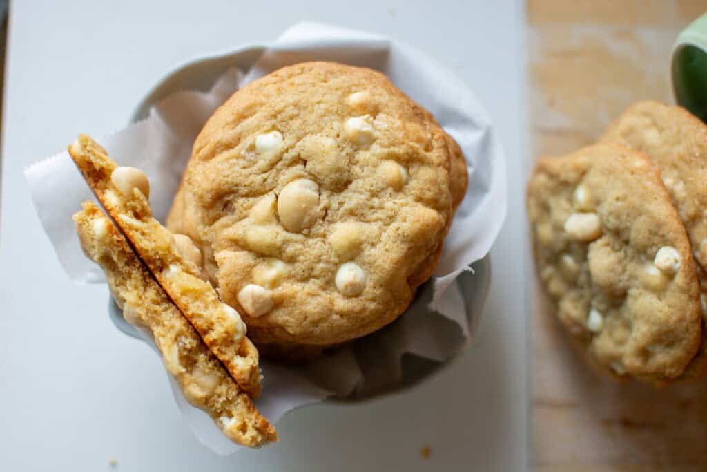 white chocolate macadamia nut cookies with one broke in half.