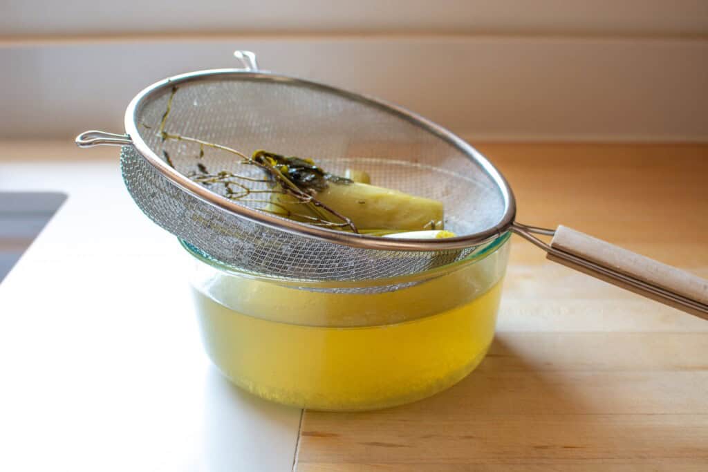 chicken broth with a strainer on top