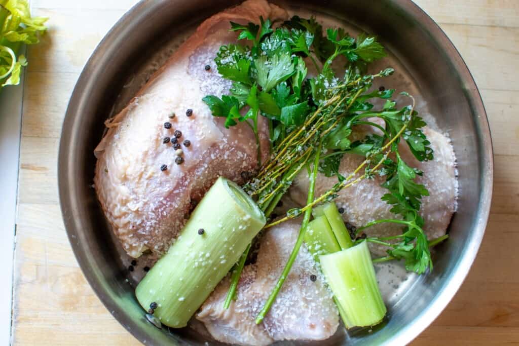 chicken in a pot with leeks and parsley
