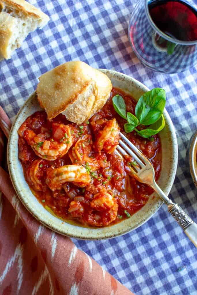 shrimp in tomato sauce on a purple and white checkered cloth