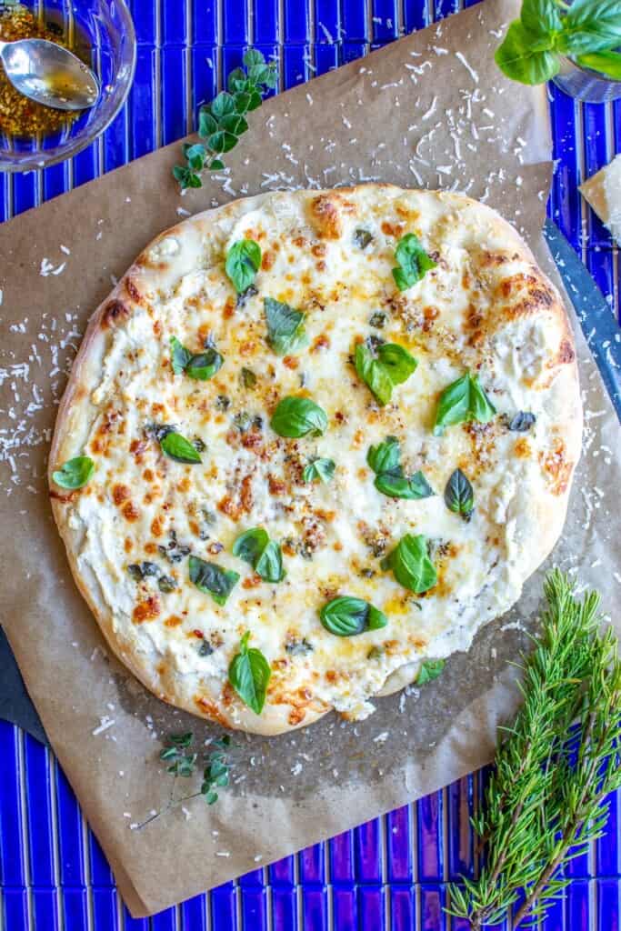 a white pizza with basil on top
