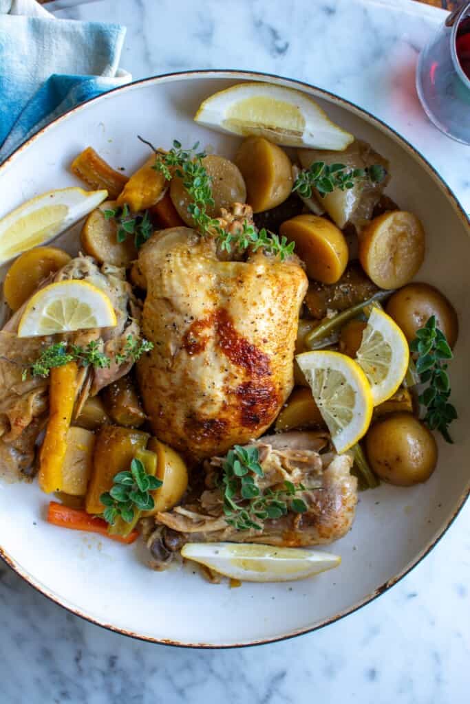 a whole chicken on a plate with vegetables
